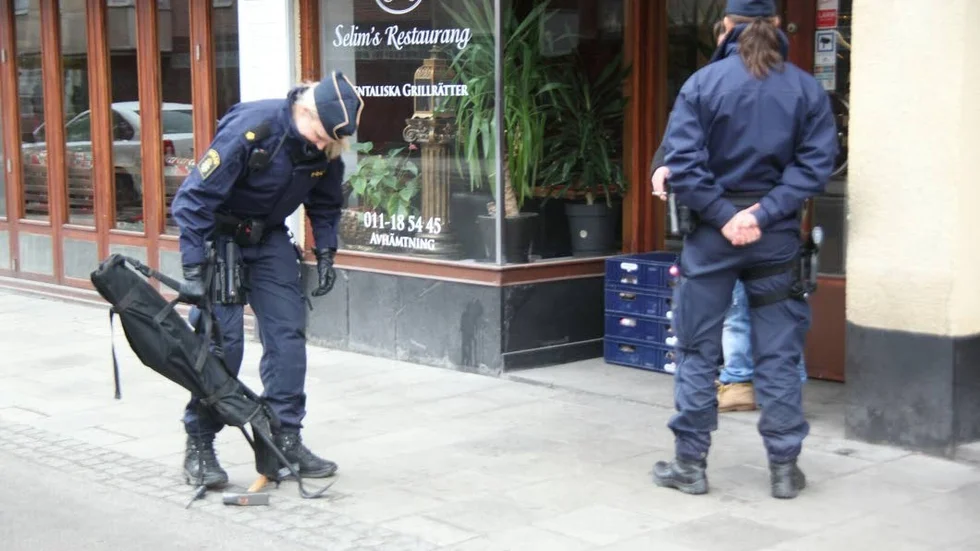 Tillslag. Polis beväpnad med kofot och hammare vid tillslaget på Repslagaregatan.