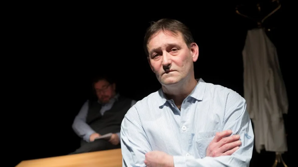 Slas-pjäs. John Hedman, som bearbetat Stig Claessons roman "Nelly" för scenen, spelar själv huvudrollen. I bakgrunden Fredrik Pettersson som läkaren.