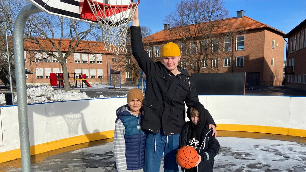 Fritidspedagogen Simon Bergholm, som här flankeras av 9-åringarna Cian och Francis, gillar basket – åtminstone som sommaraktivitet. Strängnäs kommun är på gång med att investera i en ny plan, dock inte just här på Vasaskolan.