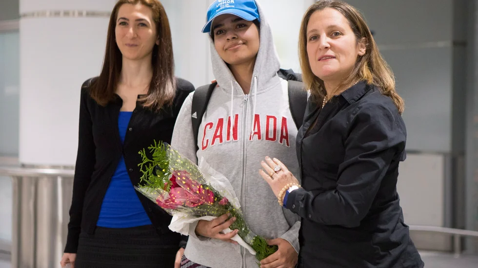 Rahaf Mohammed Alqunun, 18, center, stands with Canadian Minister of Foreign Affairs Chrystia Freeland, right, as she arrives at Toronto Pearson International Airport, on Saturday, Jan.12, 2019.   (AP)