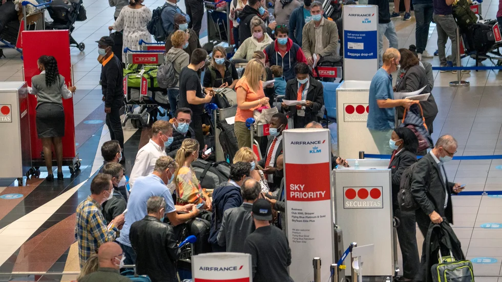 Långa köer på Johannesburgs internationella flygplats efter att larmet om den nya virusvarianten fått många länder att införa flygstopp för resenärer från Sydafrika.