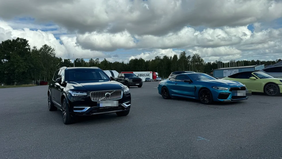 Kungens blå BMW till höger och livvakternas Volvo till vänster. 