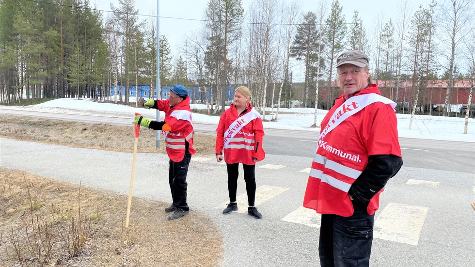 Kai Mattsson, Katja Nordin och Erik Anders Iverstrand sätter upp en "strejkskylt" vid nya kyrkogården i Jokkmokk.