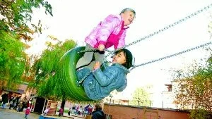 Till skratt och jubel intog barnen på Mariagården, här Wilma och Cindy, sin upprustade lekplats.