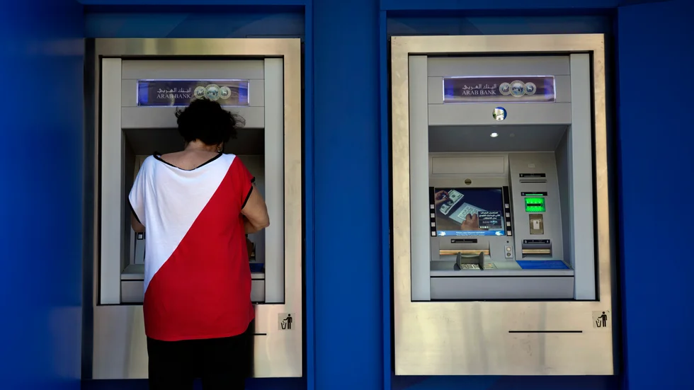 En kvinna tar ut pengar i en bankomat i Beirut tidigare i september.