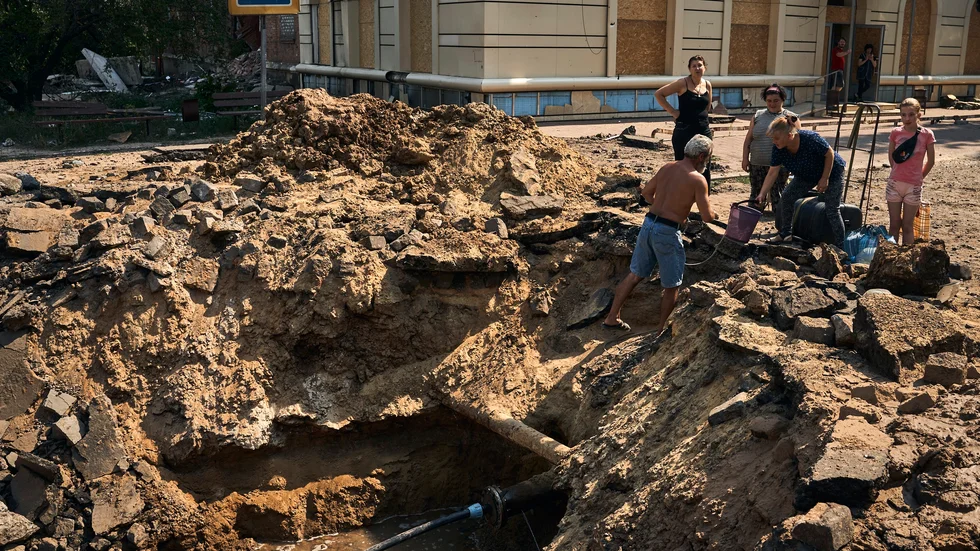 Invånare i Bachmut som Ryssland beskjuter oavbrutet försöker hämta vatten ur en krater efter ett bombanfall. Bild från 31 augusti.