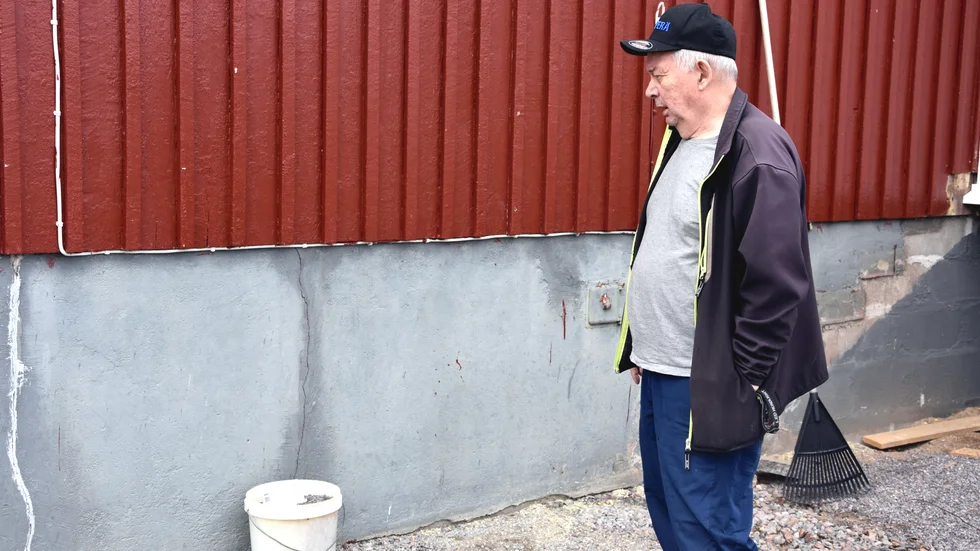 Timo Koivuranta visar sprickorna i grunden som finns runt hela huset.