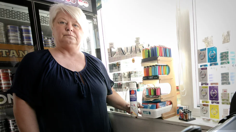 Anna-Lotta Ekstedt ägare till Lännakiosken säljer tändare från bakom disk. Här visar hon upp en påfyllningsbehållare med gas som inte står framme synligt.