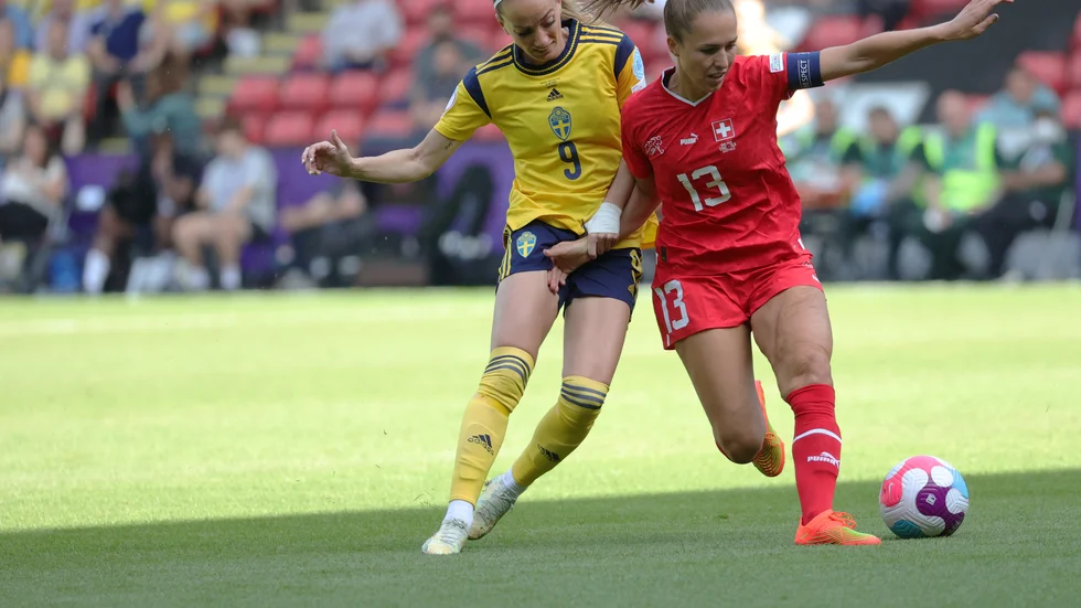 Sveriges Kosovare Asllani (i gult) och Schweiz Lia Wälti (i rött) under EM 2022. Arkivbild.
