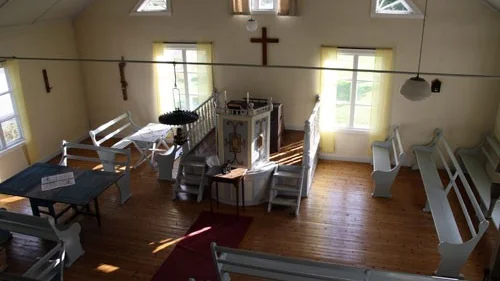 Det stora kyrkrummet i Fröreda missionskyrka är ljust och välbevarat och på väggerna hänger det konstverk av Roy Habbe.