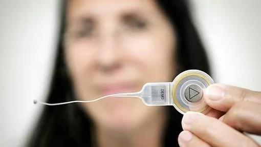 Öronkirurgen Karin Strömbäck visar upp det nya hjälpmedlet. Utöver den lilla ljudförstärkaren som placeras i mellanörat består det av en kabel, en inre mottagare och en yttre ljudprocessor som placeras bakom ytterörat.