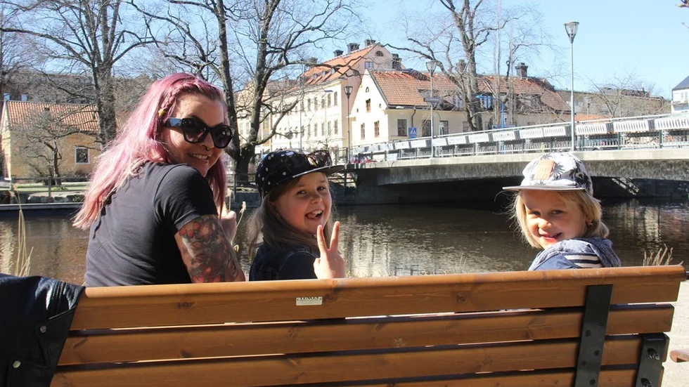 Cecilia, Elma och Dante Zillén lapar sol vid Fyrisån. "För att skydda sig mot sol ska man ha solkräm", säger Elma. Om de har det? "Näää". Men när de är utomands är krämen på.