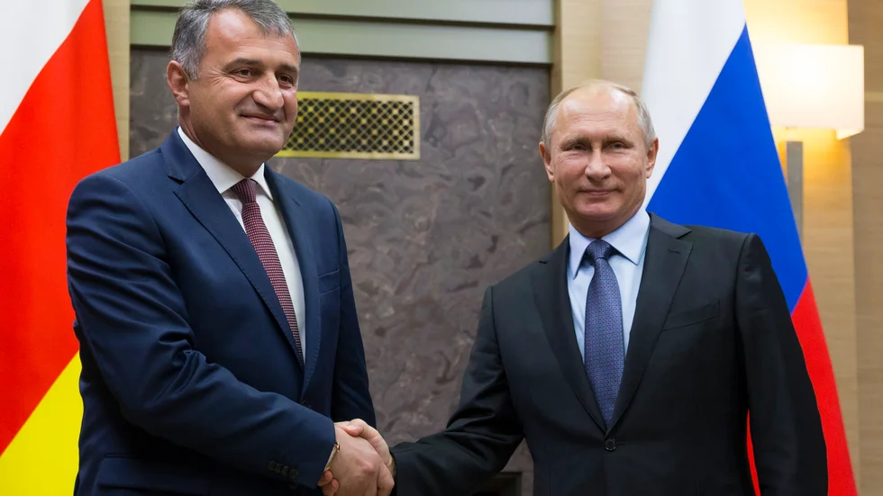Sydossetiens separatistledare Anatolij Bibilov och Rysslands president Vladimir Putin skakar hand vid ett möte i Moskva 2017. Arkivbild.