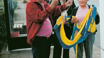 Sören Engdahl, Sven-Ove Karlsson och Iris Hermansson från Lions satte upp vimplar på torget igår. Foto: Rebecca Carlsson