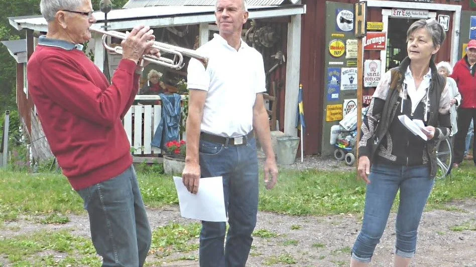 Ceremoni. Bror Ekström hyllas med en trumpetfanfar av Gullmar Andersson. Sockenföreningens ordförande Helén Jerrebrant tittar på.