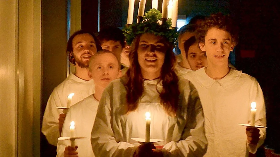 Lucia med stjärngossar och tärnor i följe tågar in i aulan på Västerviks Gymnasium.
