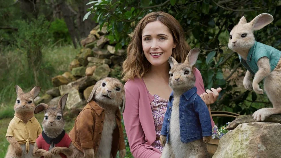 This image released by Columbia Pictures shows Rose Byrne with characters, from left, Mopsy, voiced by Elizabeth Debicki, Flopsy, voiced by Margot Robbie, Benjamin, voiced by Colin Moody, Peter Rabbit, voiced by James Corden and Cottontail, voiced by Daisy Ridley in a scene from "Peter Rabbit." (Columbia Pictures/Sony via AP)