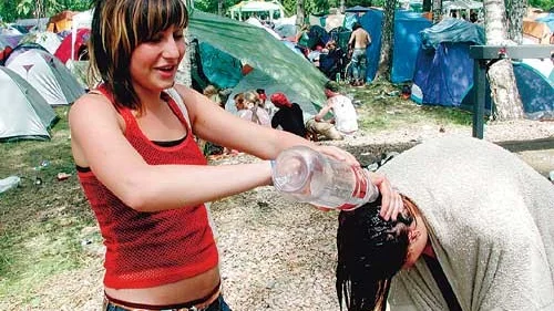 Lisa Persson tvättar under milda protester kompisens hår redan första festivaldagen. Själv ska hon vänta tills på söndag.