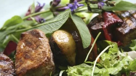 Grillspett med fläskkött, korv och grönsaker kryddas med färsk salvia.