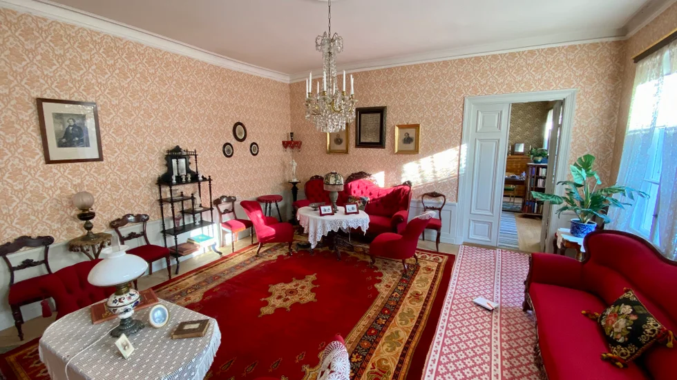 Finrum med mycket röd sammet. Så här kunde det se ut i ett högborgerligt hem i Uppsala under andra halvan av 1800-talet.