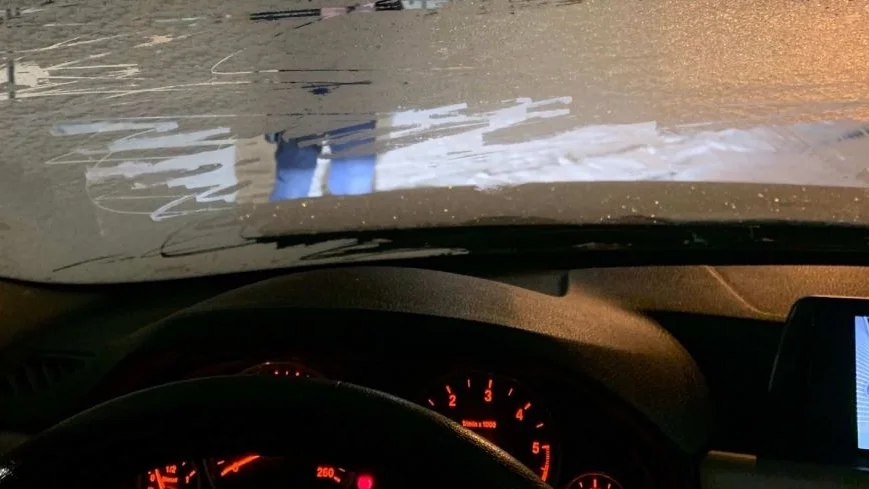 Polisen syns knappt, på andra sidan den nedisade framrutan.