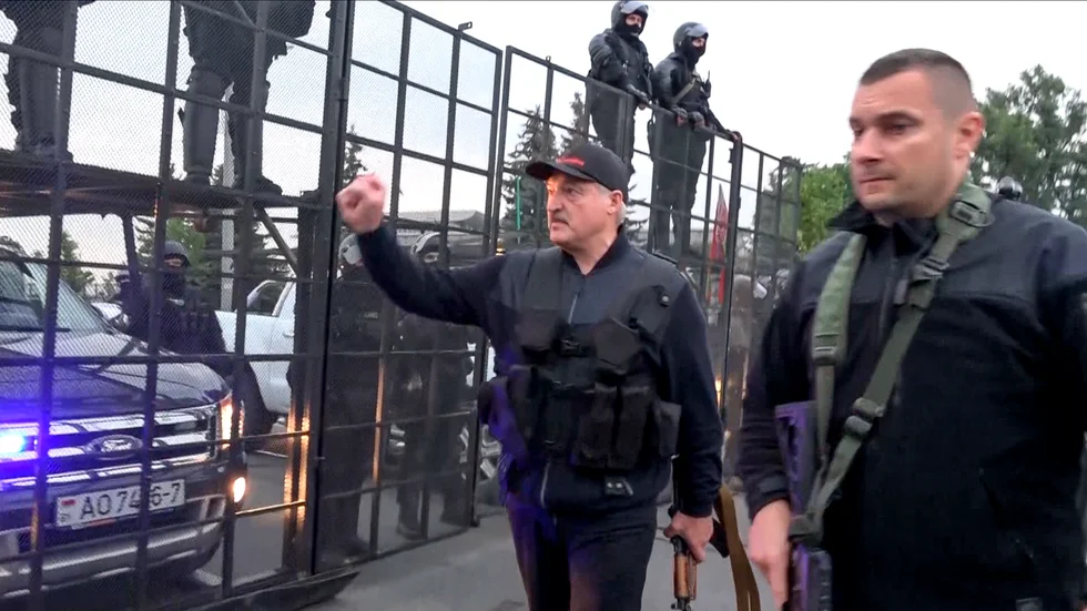 En stillbild från statlig belarusisk tv visar Aleksandr Lukasjenko, beväpnad och iförd skottsäker väst, nära presidentpalatset i Minsk den 23 augusti.