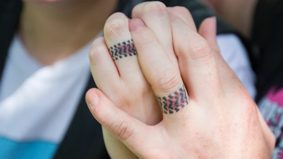 Bild från vigsel 2020. "De går inte att slarva bort", säger paret Andersson Gullstrand om sina tatuerade viselringar. Däckspåret berättar om deras gemensamma kärlek till raggarkulturen.