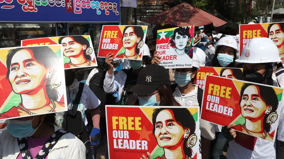 Demonstranter håller upp plakat med bilder på Myanmars avsatta civila ledare Aung San Suu Kyi under en protest mot militärjuntan i Mandalay i centrala Myanmar den 5 mars.