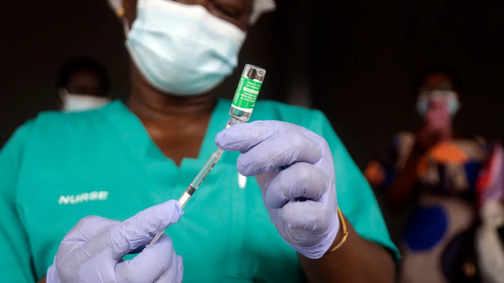 En sjuksköterska i Nigeria förbereder dos coronavaccin. WHO varnar nu för att den afrikanska kontinenten riskerar att drabbas av en ny covidvåg på grund av försenade leveranser och problem med att få ut de doser man har.