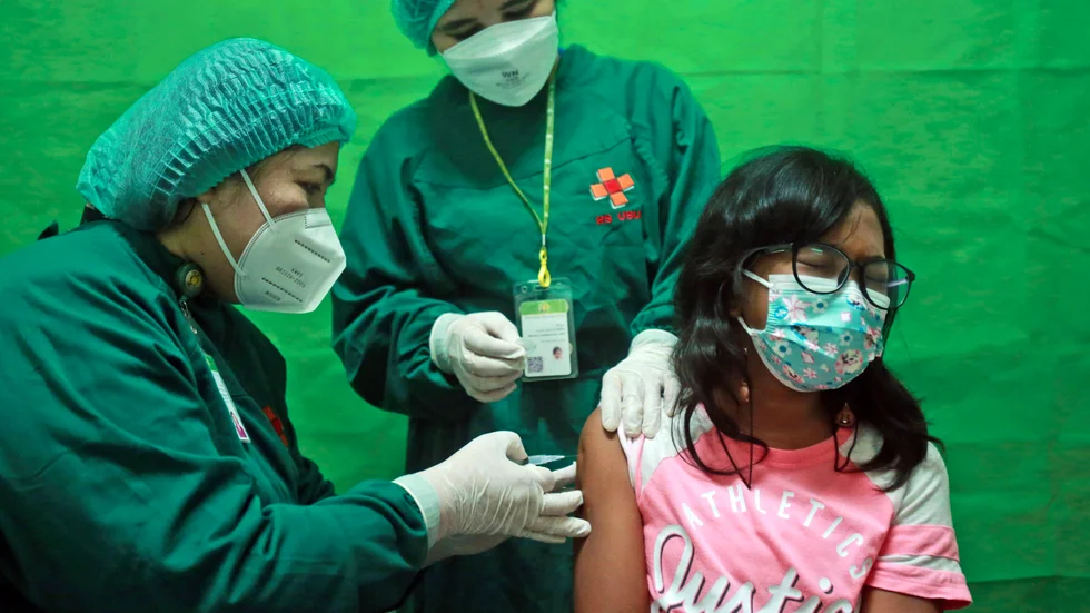 En flicka vaccineras med det kinesiska Sinovacs vaccin mot covid-19 i staden Medan på norra Sumatra i Indonesien. Bilden är från i juli.