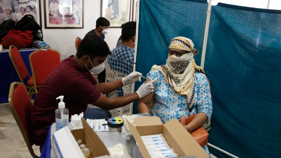 Männiaskor vaccineras mot covid-19 på ett vaccinationscenter i Ahmedabad i Indien.