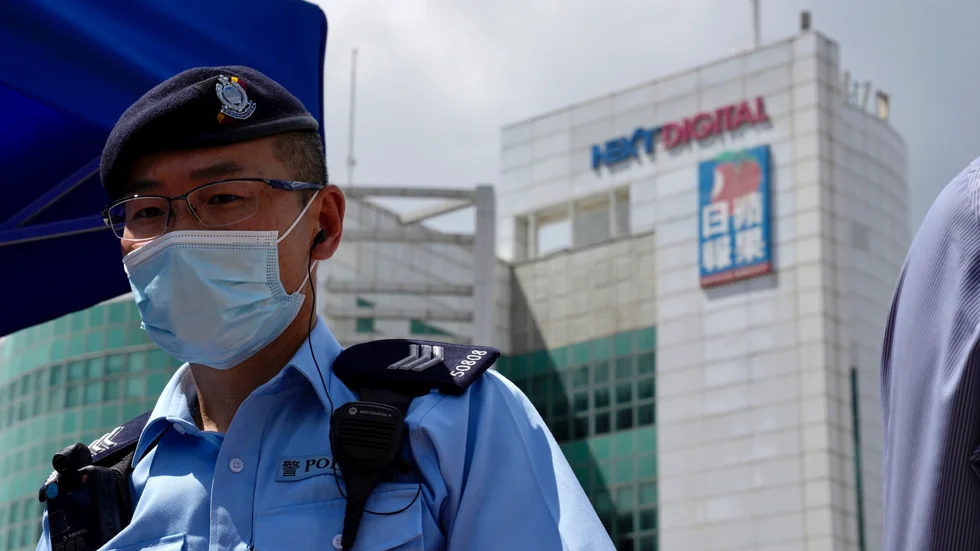 En polis står vakt utanför Apple Dailys redaktion i Hongkong.