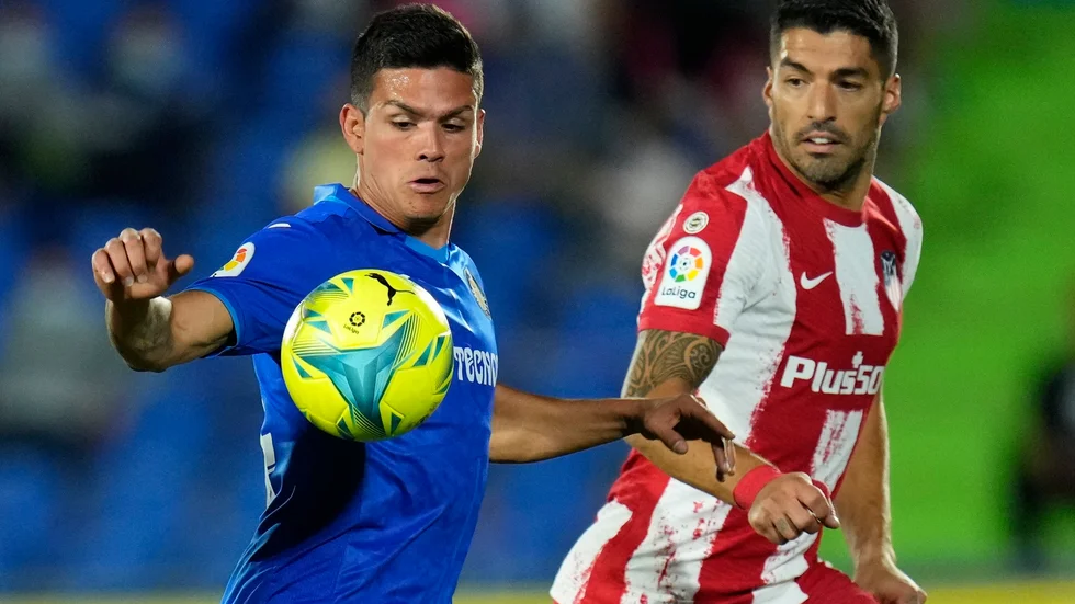 Luis Suarez (till höger) gjorde två sena mål för Atlético Madrid som vann borta mot Getafe.