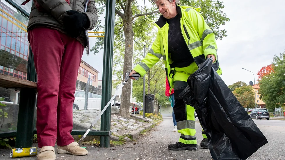 Agneta Johansson plockar upp fimpar vid busshållplatsen vid Stockholmsvägen.