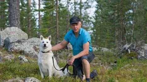 Kåre Larsson med sin vita älghund Swix. En av de hundar som godkändes vid Permobilbjörntestet i Kronogård första helgen i augusti. Nu väntar björnjakt på riktigt, och kanske, kanske blir det i höst som första björnen skjuts för Swix.