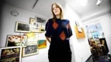 FORMULERAR FRÅGOR. Konstnären Nina Svensson på plats hos Galleri Syster och mitt i berättelsen om Gullfiberfabrikens konstförening. På väggen bakom henne syns verk av bland annat Lars Norrman och en klocka som står och hackar på kvart i tio som hon hittade på kontoret.