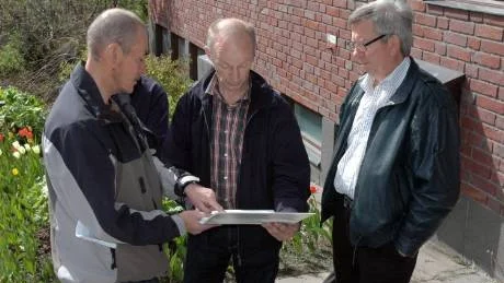 STÄMMER INTE. Kuttainenborna Isak Töyrä och Arne Esberg visar skolutredningen för Dick Vånsjö, Norrbottens sjukvårdsparti. "Det finns felaktiga uppgifter i utredningen", säger Arne Esberg som är orolig för att skolan läggs ner. "Skolan är livsviktig för hela byn. Vem flyttar hit om vi inte har någon skola?", säger han. Foto: Åsa Poromaa