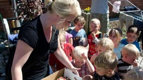 MUMS. Prischecken i alla ära. Men barnen flockades runt tårtan, förstås. Förskolechefen Bia Lundberg med prischecken i bakgrunden.