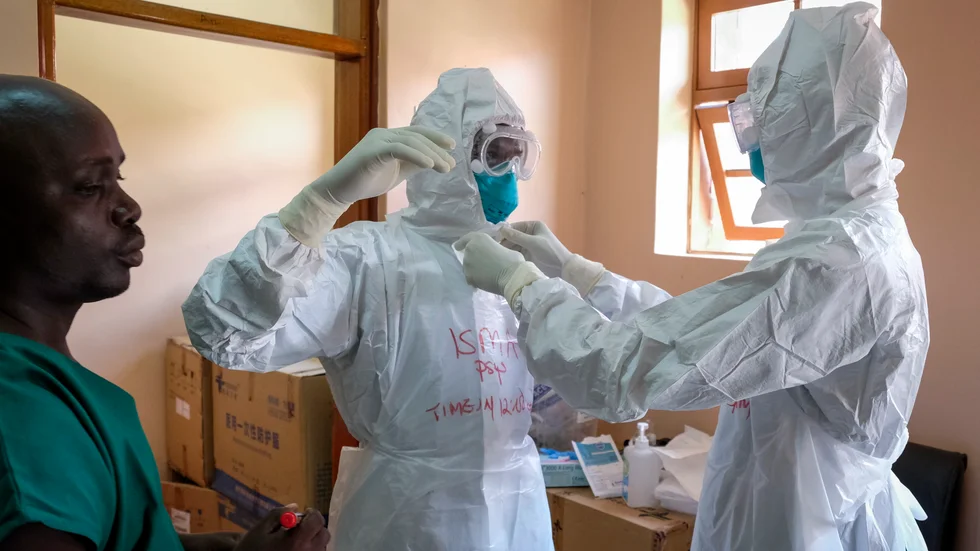 Läkare tar på sig skydd inför hantering av ebolapatienter i Entebbe, Uganda, i torsdags förra veckan. Arkivbild.