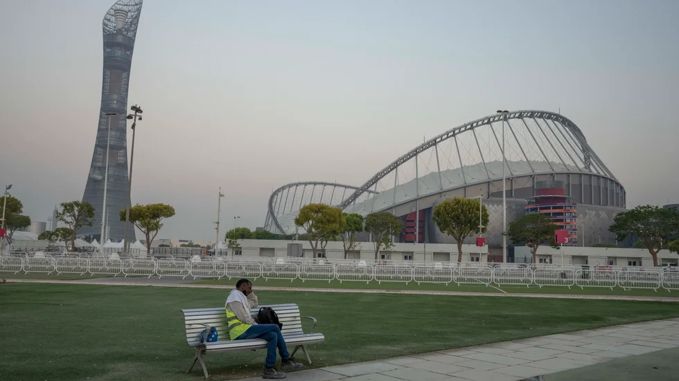 En migrantarbetare vilar framför Khalifa International Stadium, där VM-matcher ska spelas.
