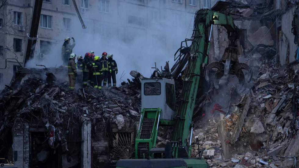 Räddningsarbetare söker i bråten efter bostadshuset som förstördes i en rysk attack i ett bostadsområde i söndags.