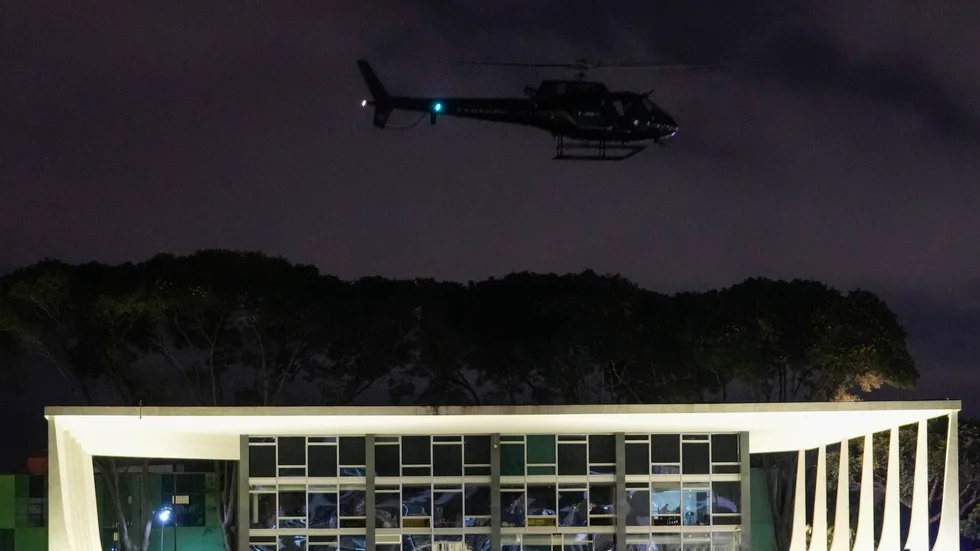 En polishelikopter flyger över presidentpalatsen Planalto.