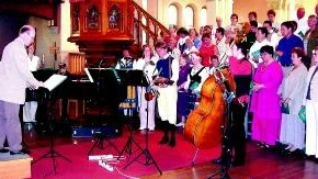 Folkmusikmässa. "I välsignan och fröjd" kräver en riktigt stor kör, flera solister och en instrumentalensemble med äkta folkton i grunden. Plus en säker ledning! Här är dirigenten Bo Ingelberg i färd med att "slå igång" pingstdagens mässa i Sankt Petri men hela kören fick långt ifrån plats på bilden.