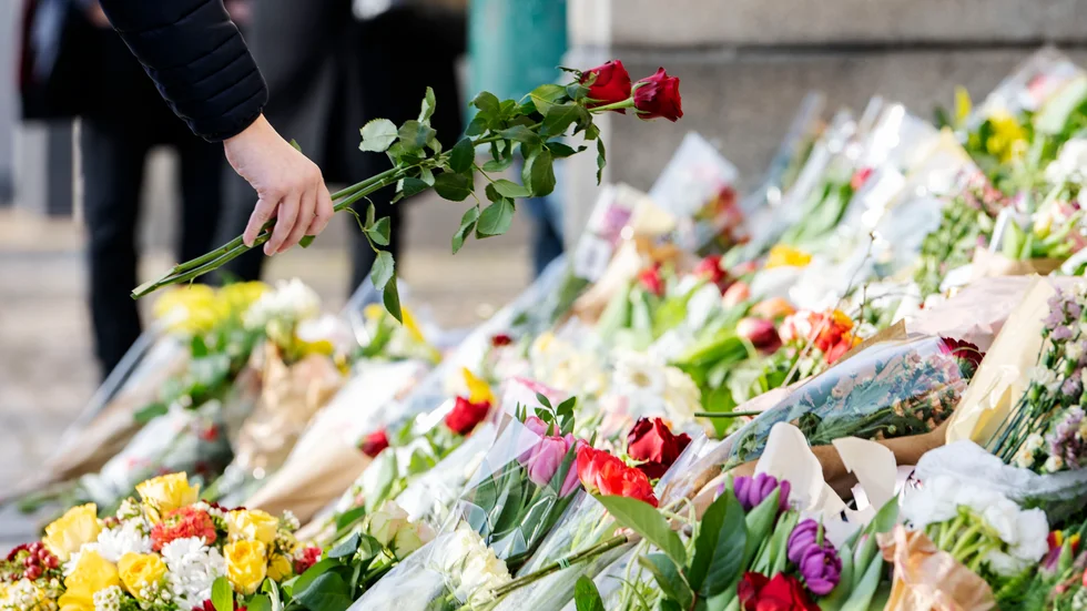 Rosor placeras i havet av blommor och ljus på trappan vid huvudentrén på Malmö Latinskola den 22 mars, dagen efter att två av skolans lärare dödats av en elev. Arkivbild.