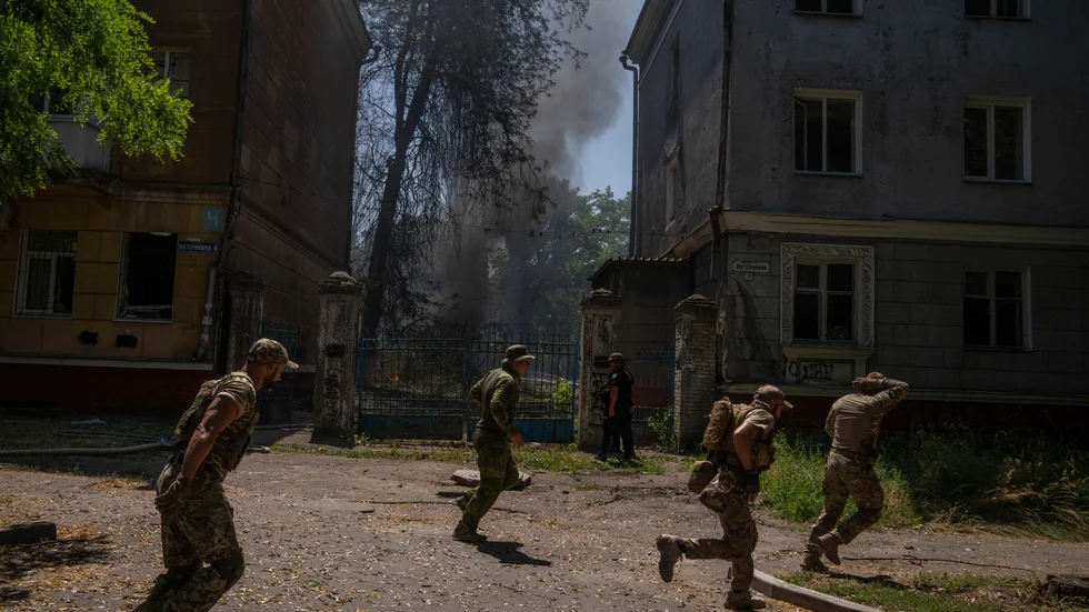 Ukrainska soldater söker skydd efter en attack mot ett bostadsområde i Kramatorsk i Donetsk.