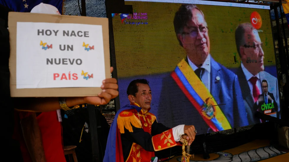 Anhängare till Gustavo Petro tittar på storbilds-tv när han svärs in som president.