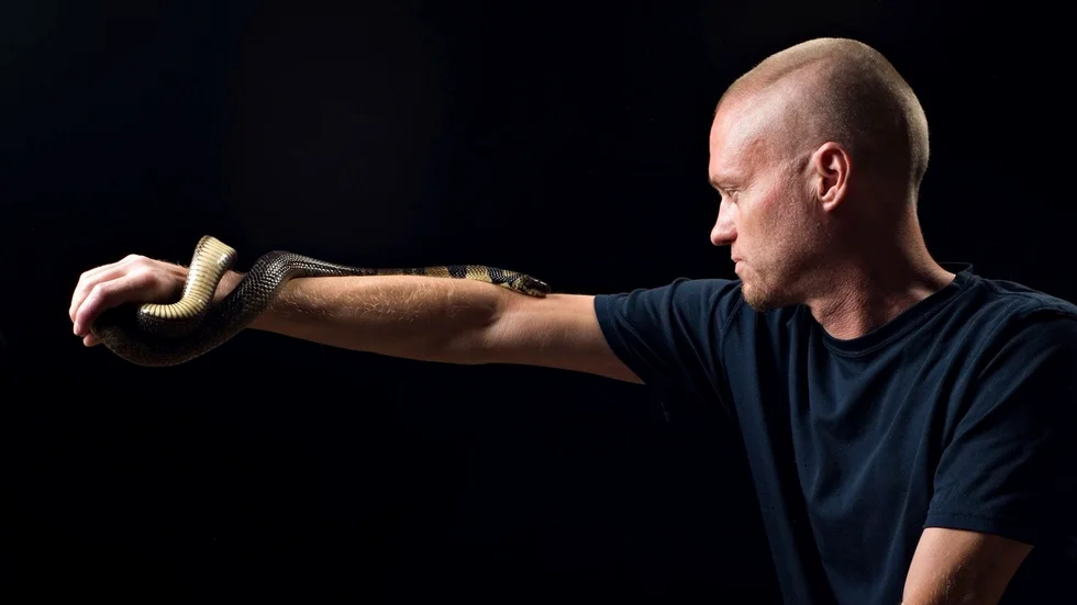 Ormsamlaren Tim Friede med en vattenkobra slingrad runt armen. Arkivbild.