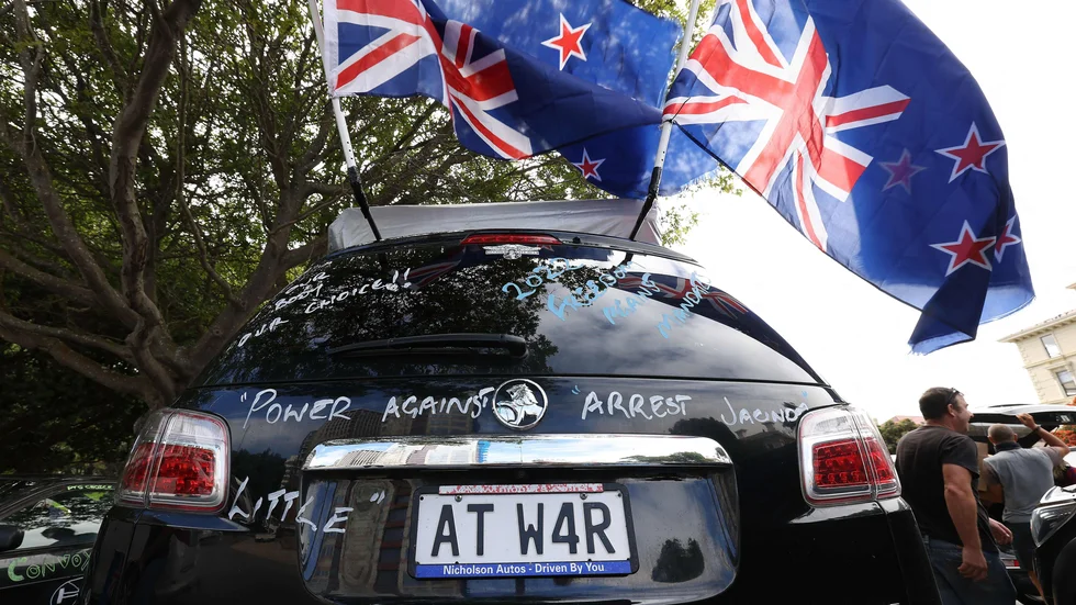 Demonstranter i närheten av parlamentsbyggnaden i Wellington med upp och nedvänd nyzeeländsk flagga.