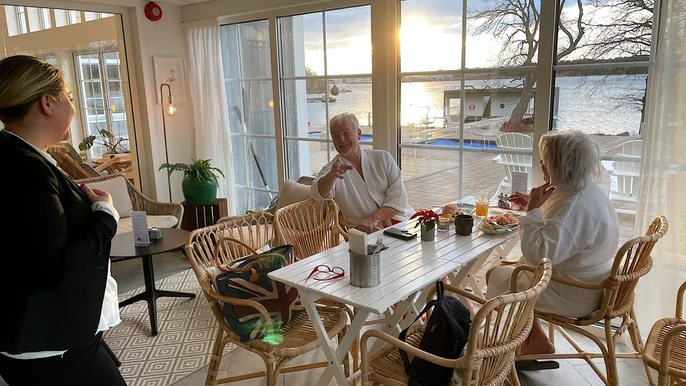 Sigrid Persdotter byter några ord med lunchgästerna Torgny Gunnarzon och Birgitta Svanbäck. Det visar sig att de fått spavistelsen i present – som del i en adventskalender – av Birgittas barn. Bakom dagens lucka: en spadag, alltså.