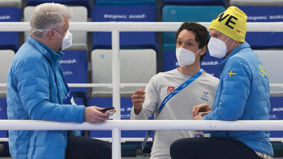 Skridskoåkaren Nils van der Poel (mitten) och hans tränare Johan Röjler (th) talar med Niclas Green från Sveriges olympiska kommitté (SOK).